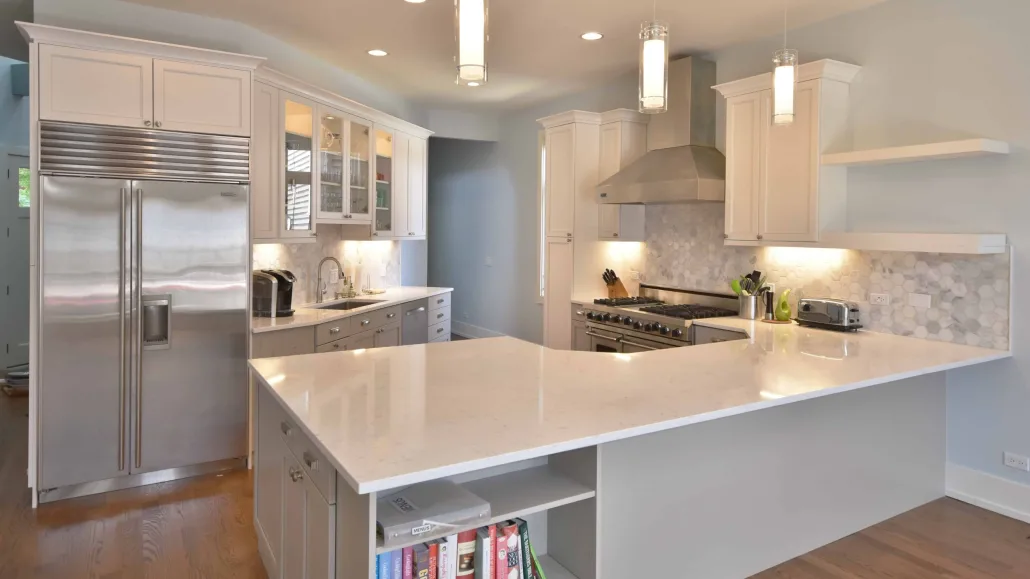 Bright kitchen remodel in Chicago featuring white shaker cabinets, white subway tile backsplash, and dark hardware by Maya Construction Group.